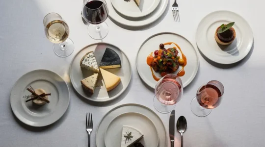 Table élégante avec verres de vins différents et plats variés créant une harmonie visuelle parfaite