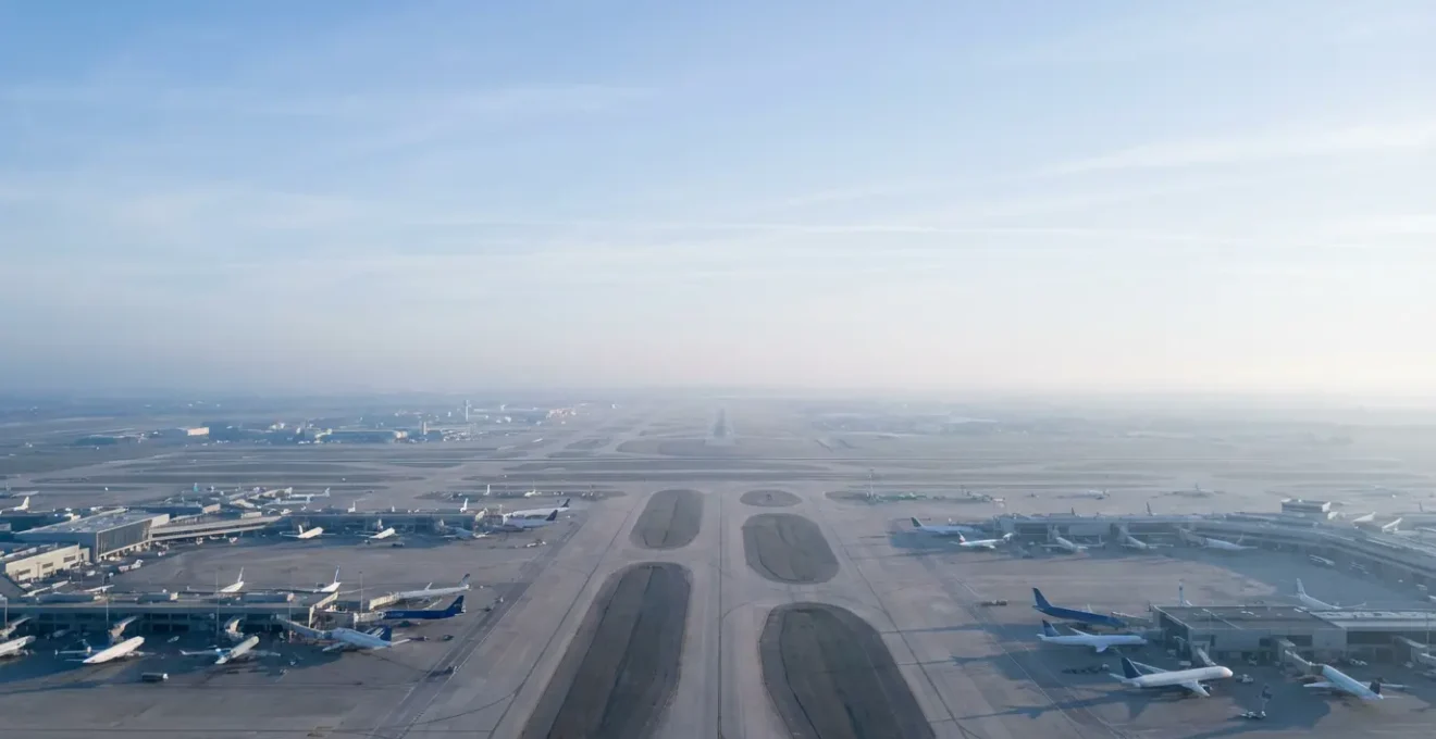 Vue aérienne d'un grand aéroport international avec multiples terminaux et avions stationnés